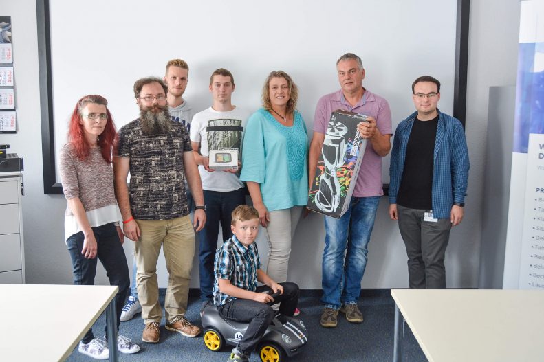 Freudige Gewinner (v.l.): Familie Kühner (3.Preis: Bobby Car), Patrick Wöhner (Assistent der Werkleitung Judenbach), Kevin Riedel (2.Preis: Navigations- system), Familie Morgenroth (1.Preis: Hoverboard) sowie Tobias Pastor (Azubi Kommunikation).
